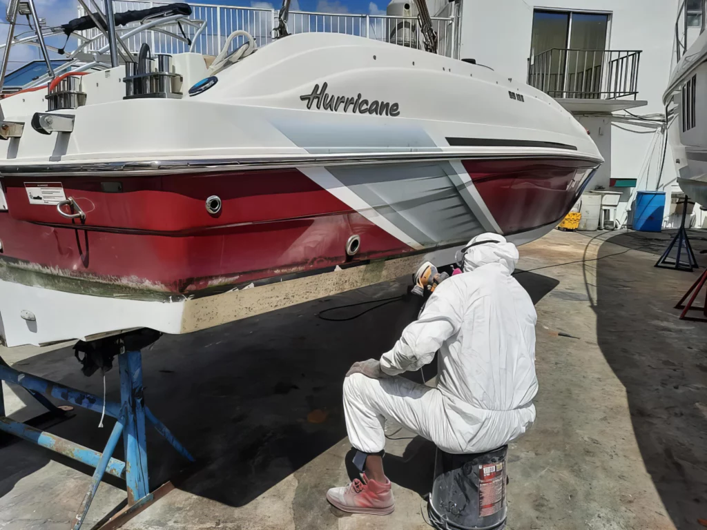 Technician sanding and detailing boat paint